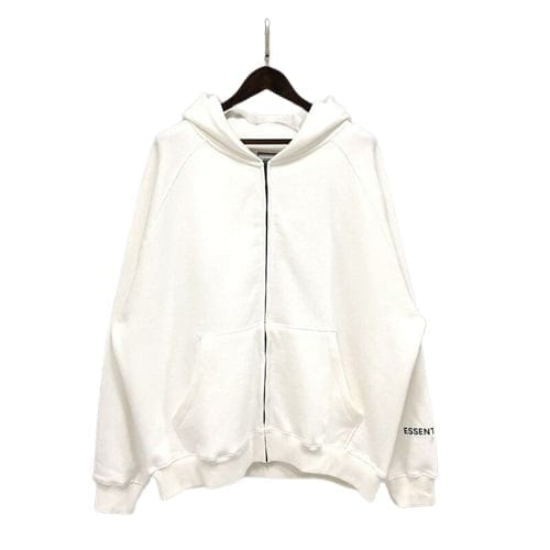 White oversized zip-up hoodie with "ESSENTIALS" logo on sleeve, casual streetwear style.