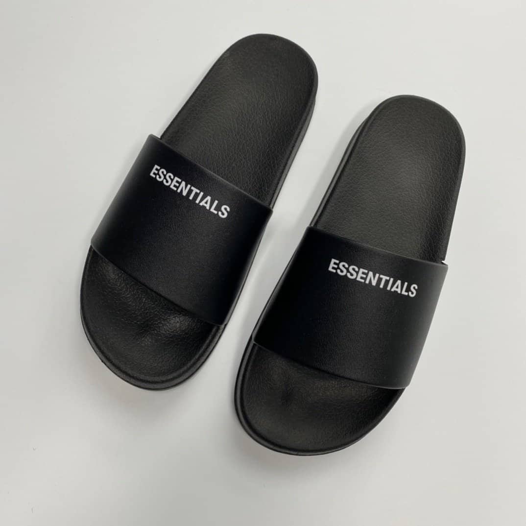 Black slides with "ESSENTIALS" text, simple and stylish kpop merchandise flip-flops, casual footwear for fans of fashion and comfort, perfect for everyday wear or music events twice kpop merch.