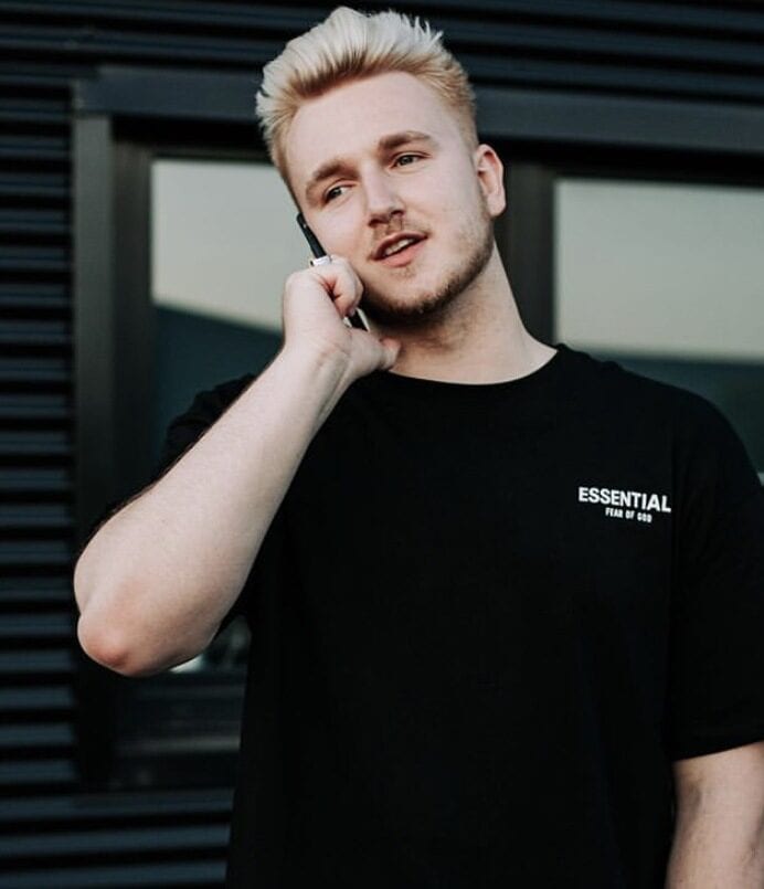 Kpop merchandise, two K-pop merch items featured in vibrant and stylish designs, perfect for fans to showcase their favorites and enjoy collecting. The image highlights a trendy individual wearing a black T-shirt with "ESSENTIAL" text, representing K-pop fashion and merchandise culture.