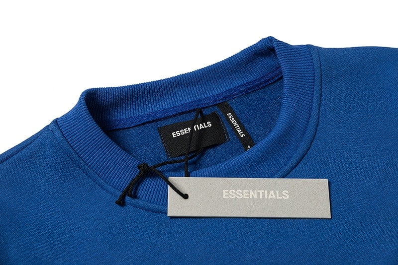 Black and white k-pop merchandise tags on a blue sweatshirt, close-up image, trendy fashion accessory, popular among fans, showcasing official branding and design elements of K-pop merch.