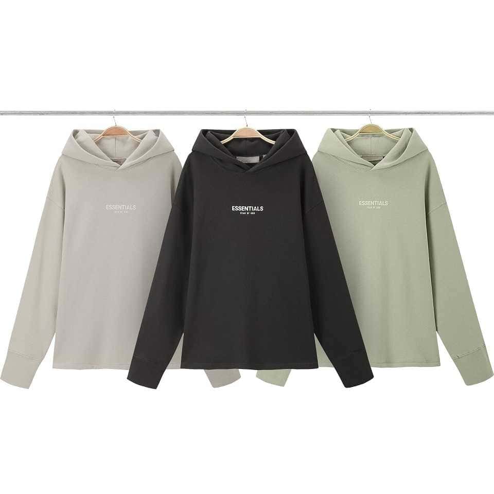 Crewneck sweatshirts in neutral colors with "ESSENTIALS" text, stacked in a fashion market display, perfect for casual wear and stylish street fashion.