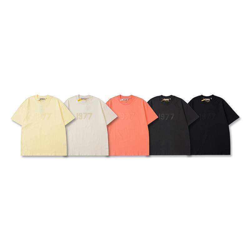 Twin kpop merchandise collection featuring colorful graphic t-shirts in yellow, white, coral, and black, each with retro styles and "1977" prints, perfect for fans of K-pop and pop culture.