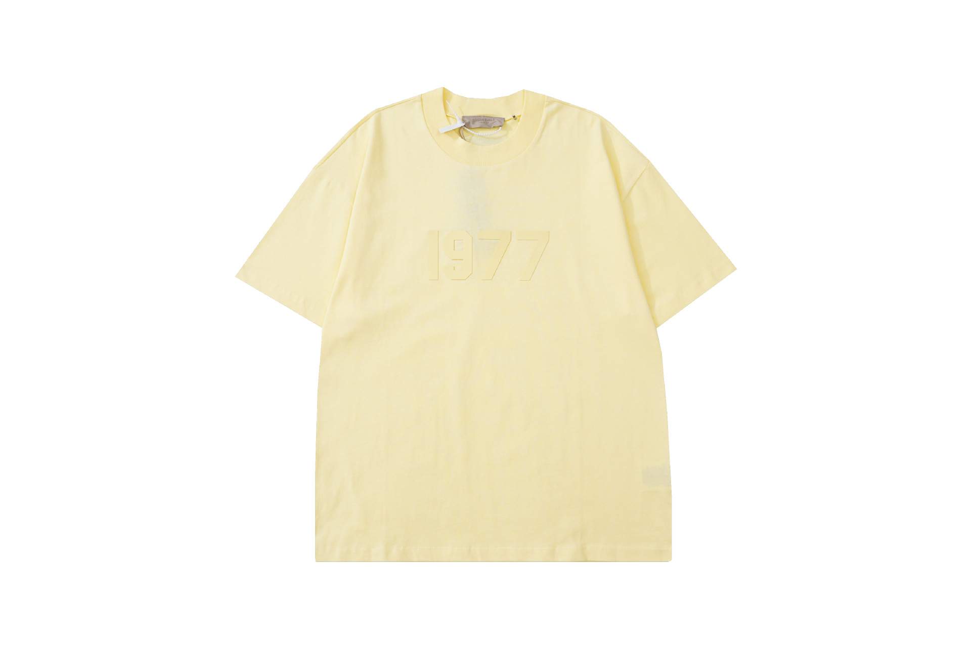 White oversized T-shirt with embossed "1977" text, casual streetwear style, popular among K-pop fans for merch collections.