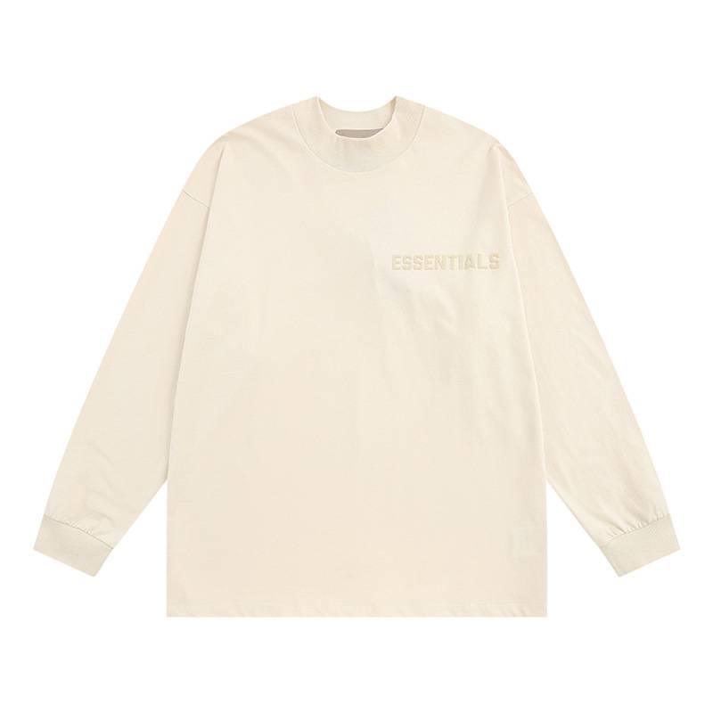 Essential long sleeve t-shirt in a cream color with subtle embroidered "ESSENTIALS" text on the chest, perfect for casual K-pop merchandise collection.