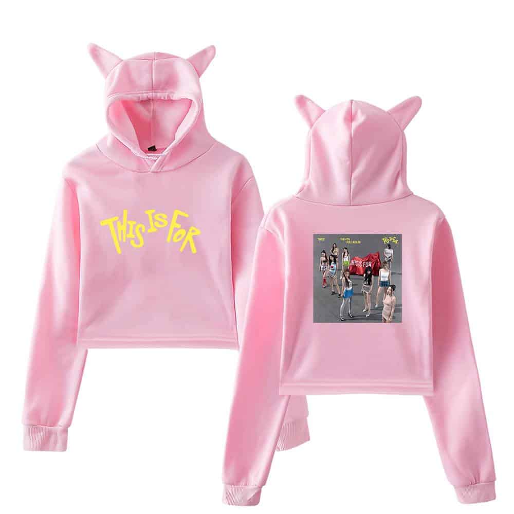 Pink hoodie with cat ears, "This Is For" text, and group photo print, trendy K-pop merchandise for fans.
